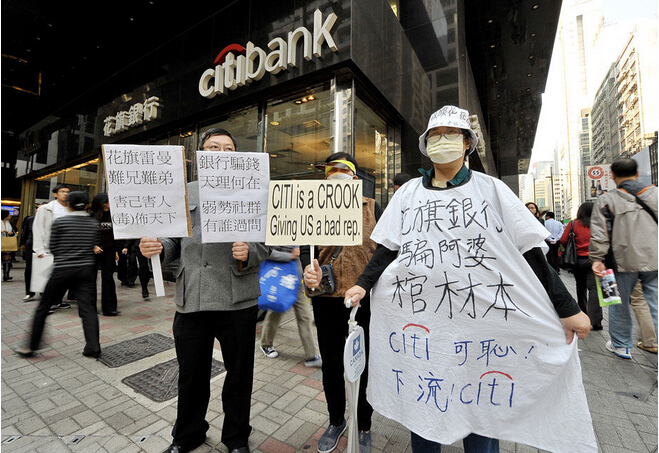 美国的次贷危机波及到中国香港和台湾后，演变出了“有毒债权”的问题，引发了很多社会争论。所谓“迷你债”就是那些组合的产品，这些组合融资的产品没有在美国卖给个人，反倒在东亚卖给了个人，引发了很多社会冲突。图为2008年12月17日，香港，示威人群在花旗银行门口高举标语牌要求银行回购雷曼迷你债券-当代金融家